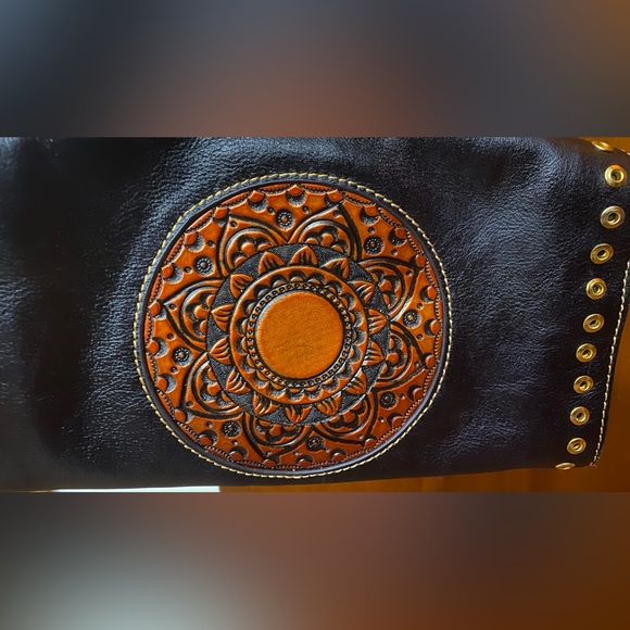 Black leather cross body purse with orange colored medallion on front. - Picture 11 of 14
